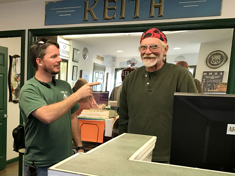 KARS employees working behind the sales counter: Beth (sales), Chris (manager), and Chuck (dismantler)